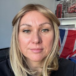 Anna Tajak - Portret kobiety z flagą Wielkiej Brytanii w tle, sugerujący naukę języka angielskiego. Widoczna półka z motywami londyńskimi.