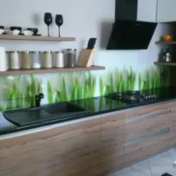 Nowoczesna kuchnia z drewnopodobnymi frontami, czarnym blatem i panelem szklanym z motywem tulipanów, widok na zlew, płytę grzewczą i okap