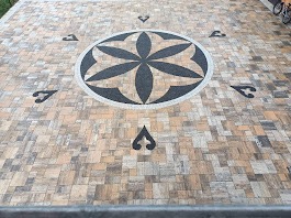 Ułożona kostka brukowa w Bukowinie Tatrzańskiej tworząca dekoracyjny wzór rozety z ciemnego kamienia na jasnym tle. Całość tworzy estetyczną i równą powierzchnię.