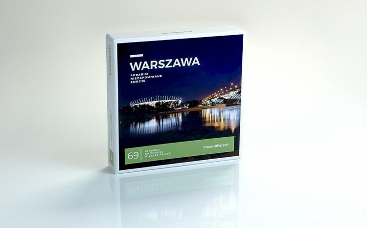 Pudełko prezentowe z nocnym widokiem na Warszawę, w tle Stadion Narodowy i most Świętokrzyski, odbijające się w wodzie. Na pudełku napis 'Warszawa. Podaruj niezapomniane emocje'.