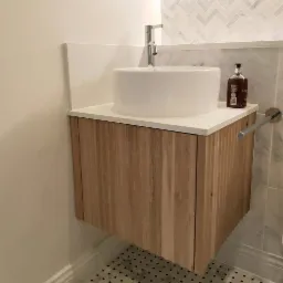 Szafka lazienkowa z drewnianym frontem.