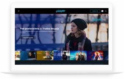 Ekran laptopa wyświetlający stronę internetową Player.pl z promowanym serialem 'Pod powierzchnią 2: Trudna decyzja', na tle widoczna kobieta w czapce i szaliku.