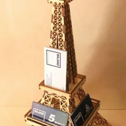 Drewniana miniatura wieży Eiffla służąca jako ekspozytor na wizytówki firmy 'Bilanz' z logo i hasłem '5 minut'.