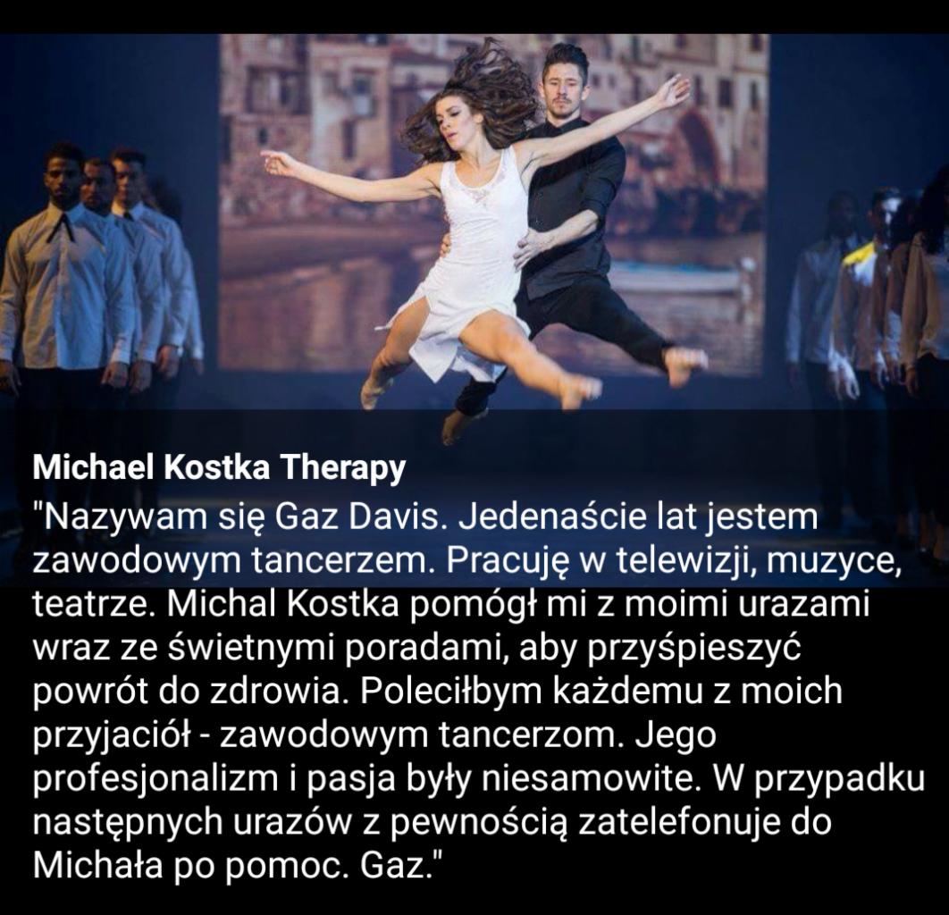 Tancerka w białej sukience podnoszona przez mężczyznę na scenie, w tle grupa tancerzy i projekcja wizualizacji scenicznej, sugerująca wsparcie w powrocie do zdrowia dla artystów.