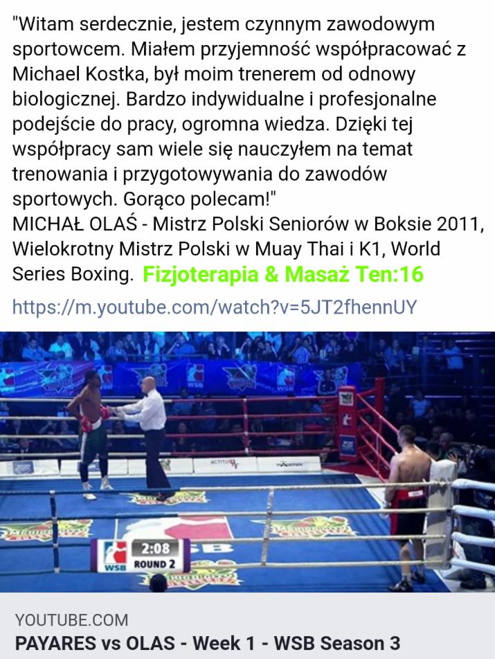 Ujęcie z ringu bokserskiego podczas walki, sędzia w białej koszuli oddziela zawodników, widoczny zegar odmierzający czas rundy, publiczność na trybunach w tle.