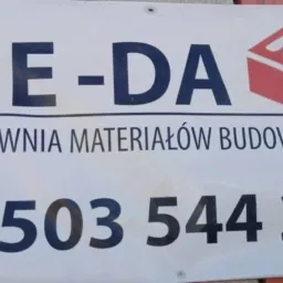 Szyld hurtowni materiałów budowlanych 'BE-DA' z numerem telefonu i grafiką cegły.