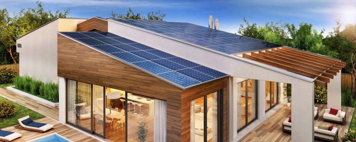 Nowoczesny dom jednorodzinny z panelami fotowoltaicznymi na dwuspadowym dachu, widok z zewnątrz na taras z drewnianą podłogą i basenem, wnętrze domu widoczne przez duże okna.