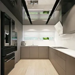 Nowoczesna kuchnia z szarymi szafkami na wymiar, białym blatem imitującym marmur i czarną lodówką, oświetlona światłem dziennym z okna z widokiem na zieleń.