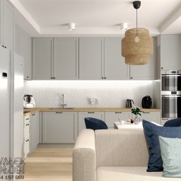 Kawałek Podłogi Projektowanie Wnętrz Karolina Kawałek - Jasnoszara kuchnia z drewnianym blatem i białymi heksagonalnymi płytkami, widok z salonu z beżową sofą i niebieskimi poduszkami, nowoczesna lampa wisząca z rafii.