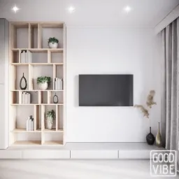 Minimalistyczny salon z drewnianym regałem wypełnionym książkami, roślinami i dekoracyjnymi wazonami, zawieszonym na ścianie czarnym telewizorem oraz neonem 'GOOD VIBE' w rogu pokoju.
