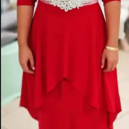 Czerwona, dwuwarstwowa sukienka z rękawami 3/4, ozdobiona srebrnym, błyszczącym paskiem na wysokości talii, zapinana na delikatną, transparentną wstążkę.