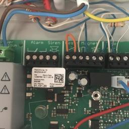 H.V.E - Podłączenia przewodów do płyty głównej centrali alarmowej BAZ04-N-UT z widocznymi terminalami Alarm, Siren, Magnet, Line, Battery i elementami elektronicznymi.