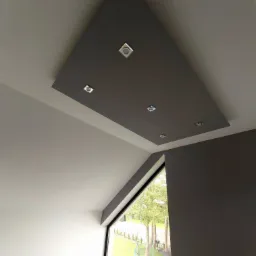 Szara, trójkątna podwieszana konstrukcja sufitowa z sześcioma punktowymi lampami LED, zamontowana w skośnym suficie mansardowym, widok na okno z ogrodem i trampoliną.