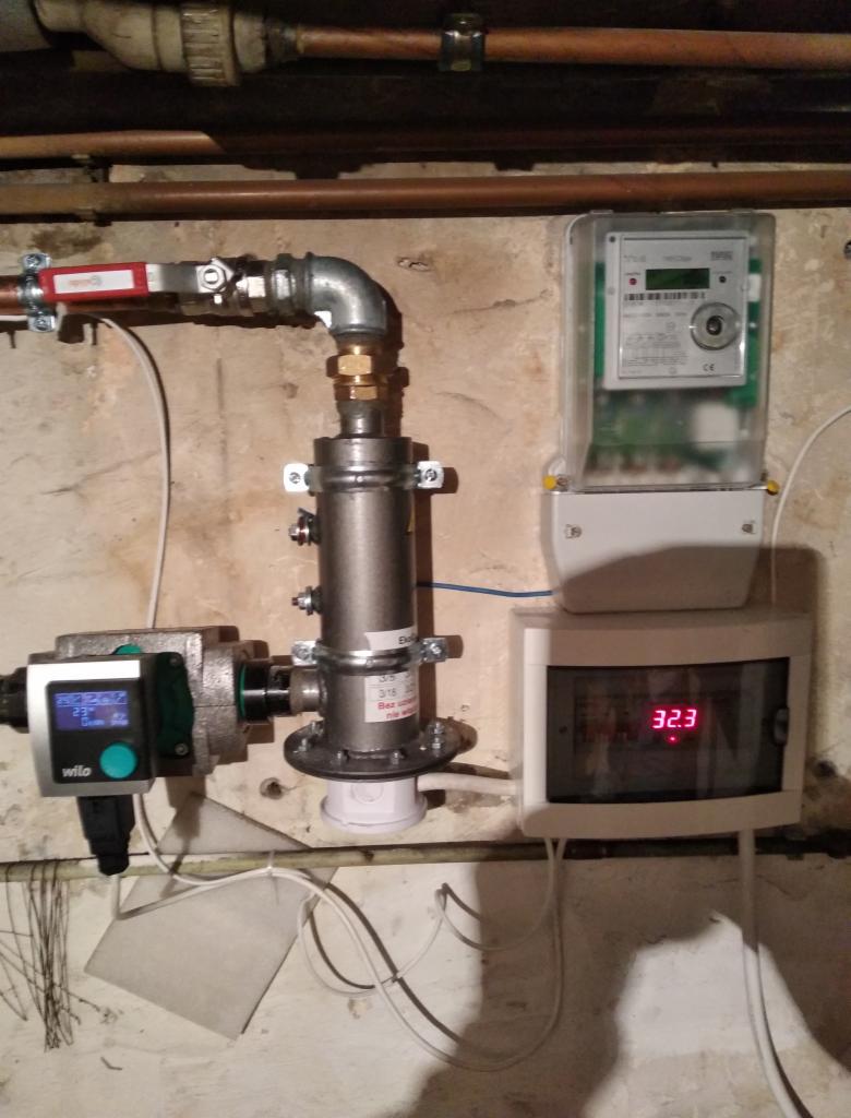 Instalacja centralnego ogrzewania z pompą obiegową Wilo, licznikiem ciepła i zaworem, zamontowana na ścianie z widocznymi rurami miedzianymi pod sufitem.