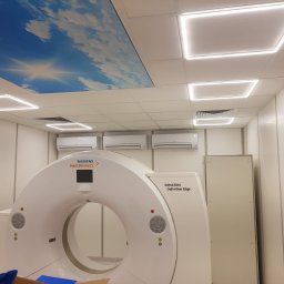 BIO - KLIM - Wnętrze gabinetu medycznego z zainstalowanymi trzema klimatyzatorami ściennymi Mitsubishi Electric nad skanerem CT firmy Siemens, oświetleniem sufitowym LED w kształcie kwadratów i sufitem...
