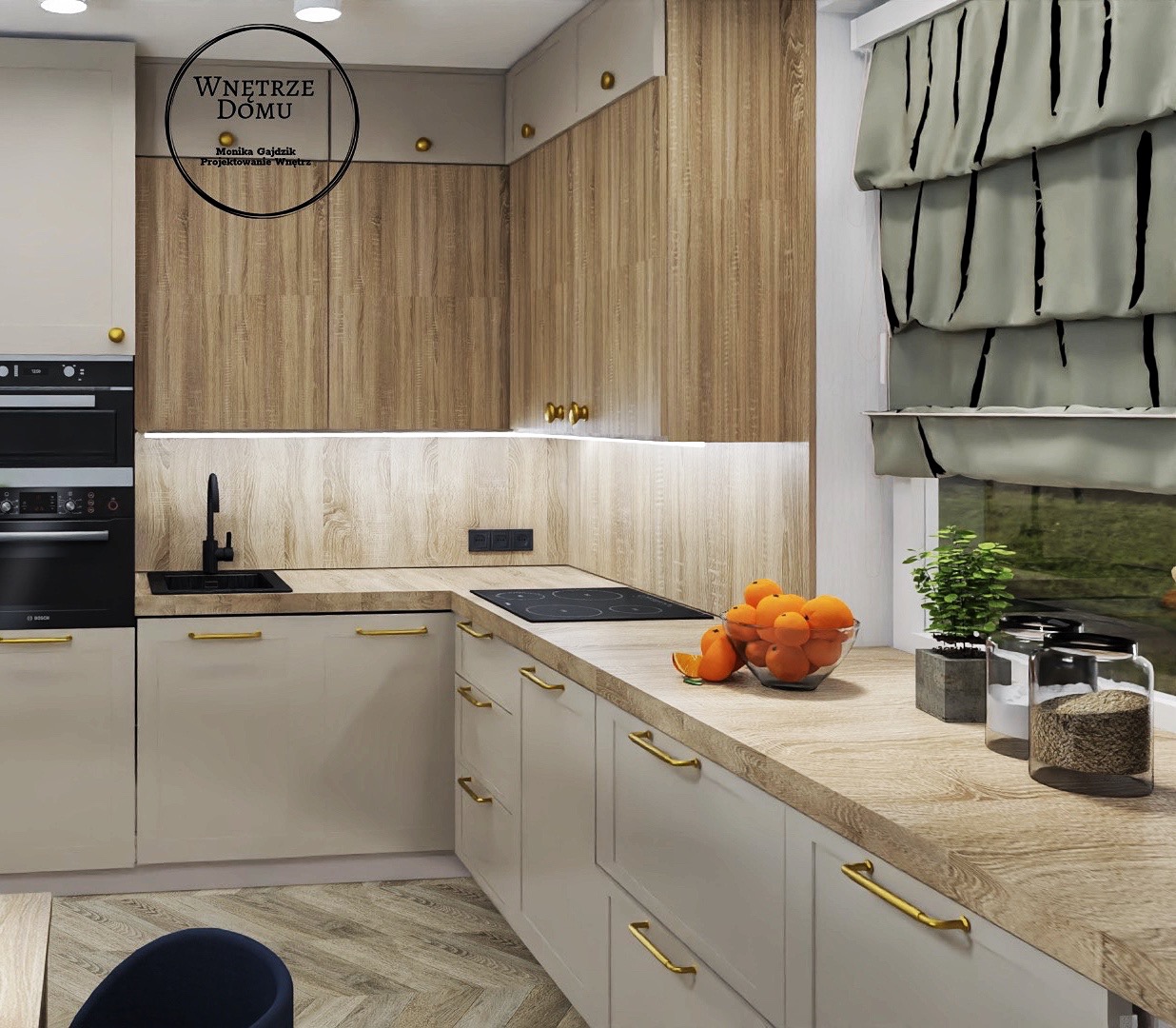 Nowoczesna kuchnia z drewnianymi akcentami, jasnymi szafkami z złotymi uchwytami, czarnym zlewem i płytą grzewczą. Na blacie szklana misa z pomarańczami, zioła w doniczce i zasłony rzymskie w oknie.