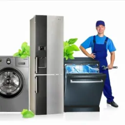 Serwisant AGD z kluczem obok pralki, lodówki i zmywarki. Świeże, zielone akcenty roślinne dodają naturalności. Uśmiechnięty fachowiec w uniformie.