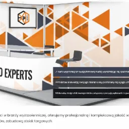 Nowoczesne stoisko targowe z logo Expo Experts, geometrycznymi wzorami w odcieniach pomarańczy i szarości, roślinami doniczkowymi i krzesłami dla klientów.