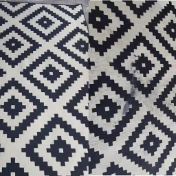 Dywan w geometryczny wzór, kontrastowe zestawienie czerni i bieli, z widocznym fragmentem wyczyszczonym, ukazującym efekt przed i po.