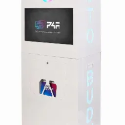 Biała fotobudka z neonowym napisem 'FOTOBUDKA' z boku, ekranem dotykowym, tęczową obwódką wokół obiektywu kamery i przezroczystym pojemnikiem z rekwizytami do zdjęć, takimi jak maski i kapelusze...