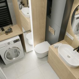 Holistic Studio Julia Ulikowska - Wizualizacja małej łazienki z pralką, umywalką nablatową i okrągłym lustrem z podświetleniem LED, wykończona drewnem i szarością, widok z góry.