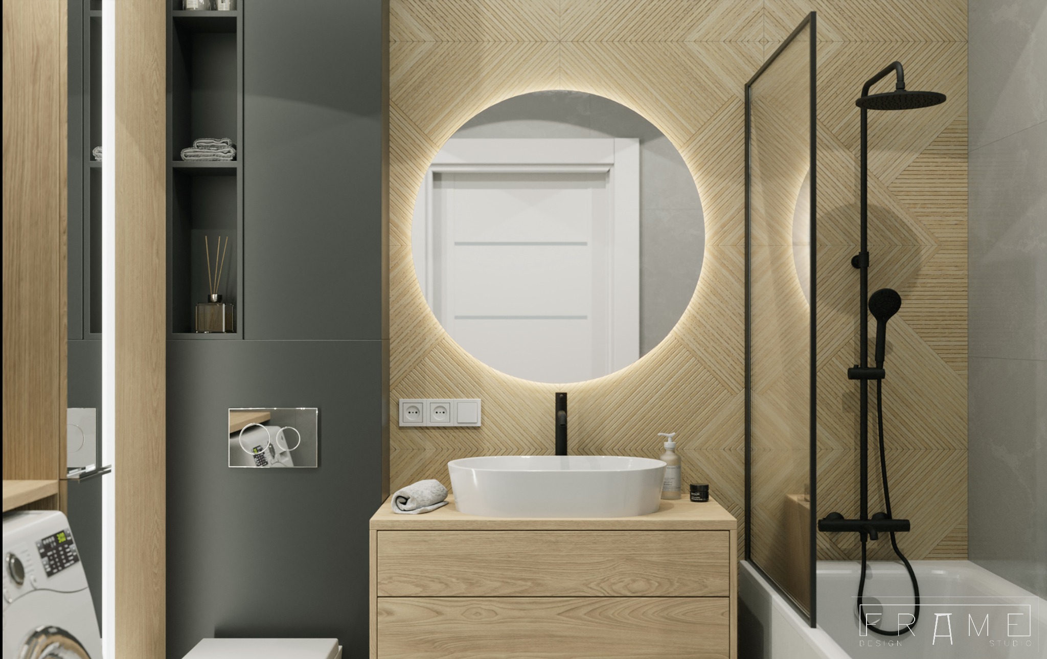 Nowoczesna łazienka z okrągłym lustrem podświetlanym LED, drewnianą szafką pod umywalką nablatową i czarną armaturą, widoczna pralka i dekoracyjne płytki na ścianie.