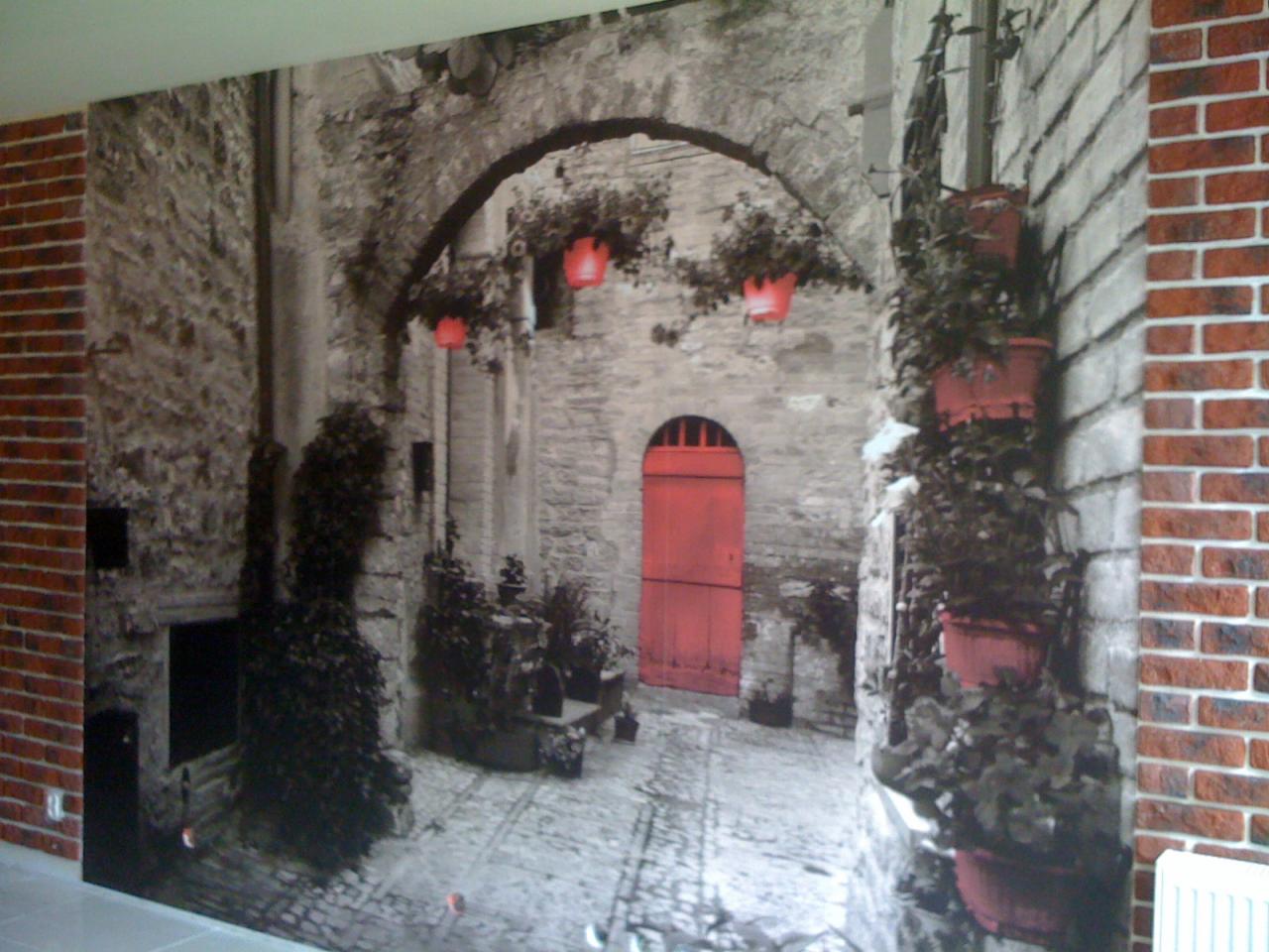 Fototapeta przedstawiająca uliczkę włoskiego miasteczka z ceglanymi elementami dekoracyjnymi na ścianach.