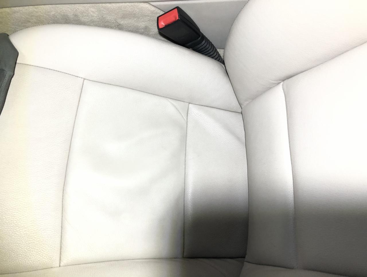 Jasna skórzana tapicerka samochodowa z widocznym zapięciem pasa bezpieczeństwa, usługa dostępna w Nidzicy.