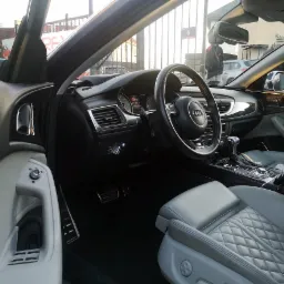 Wnętrze samochodu Audi S6 z jasną, pikowaną tapicerką skórzaną, widoczne z perspektywy kierowcy w Pruszczu Gdańskim.