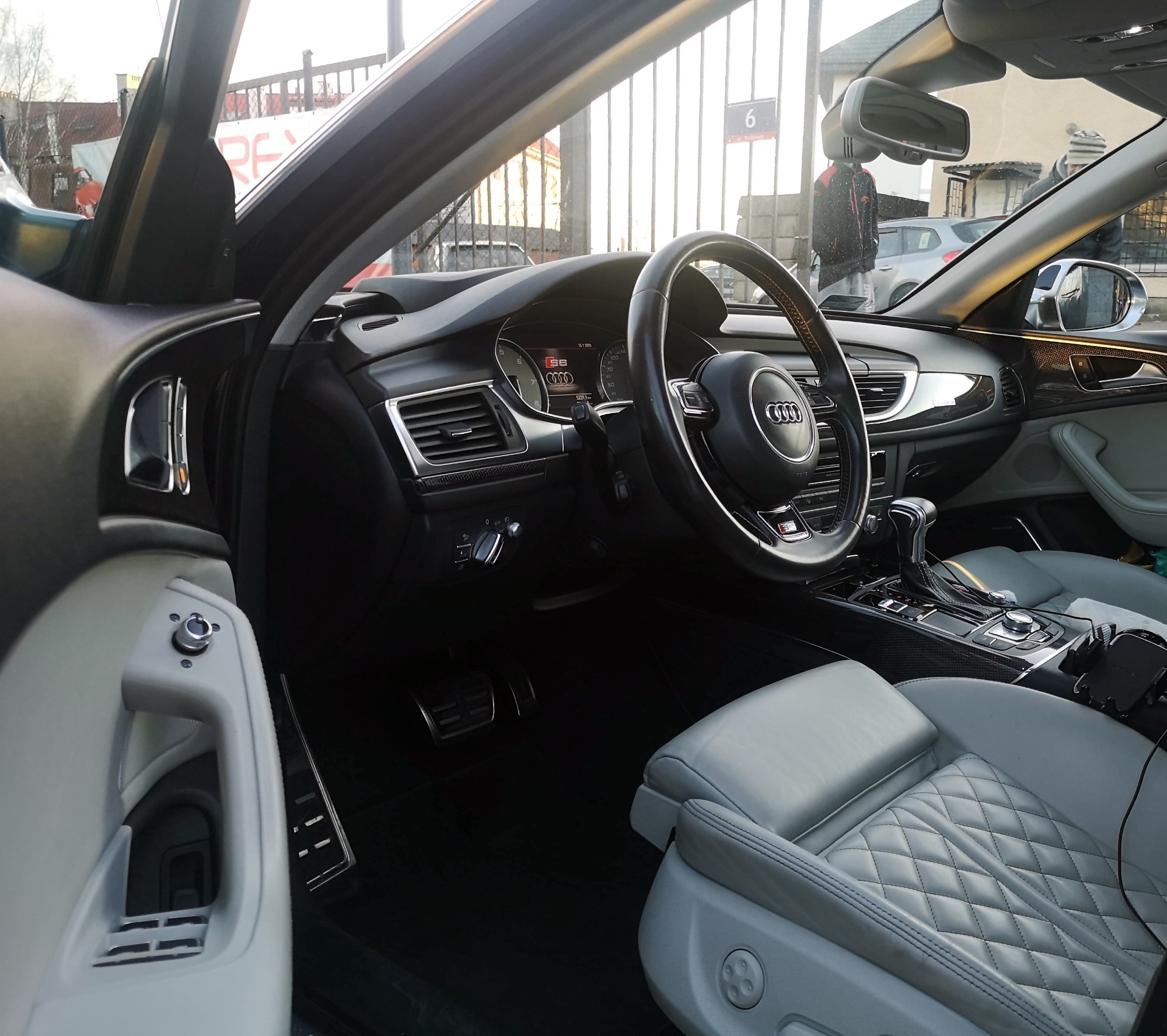 Wnętrze samochodu Audi S6 z jasną, pikowaną tapicerką skórzaną, widoczne z perspektywy kierowcy w Pruszczu Gdańskim.