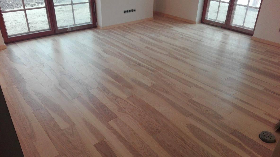 Ułożona podłoga z paneli drewnopodobnych w jasnym odcieniu, widok z góry, Bydgoszcz.