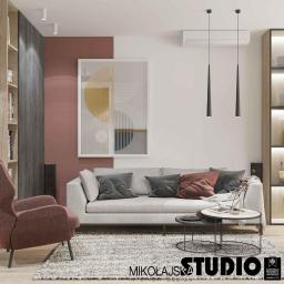 MIKOŁAJSKAstudio - Nowoczesny salon z szarą sofą, abstrakcyjnym obrazem na ścianie w kolorze terakoty i białym, oraz wiszącymi lampami w kształcie stożków.