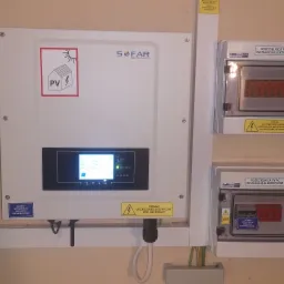 Zamontowany falownik SOFAR Solar z rozdzielnicami PV DC i PV AC na ścianie, widoczne okablowanie i oznaczenia ostrzegawcze o wysokim napięciu, instalacja fotowoltaiczna wewnątrz budynku.