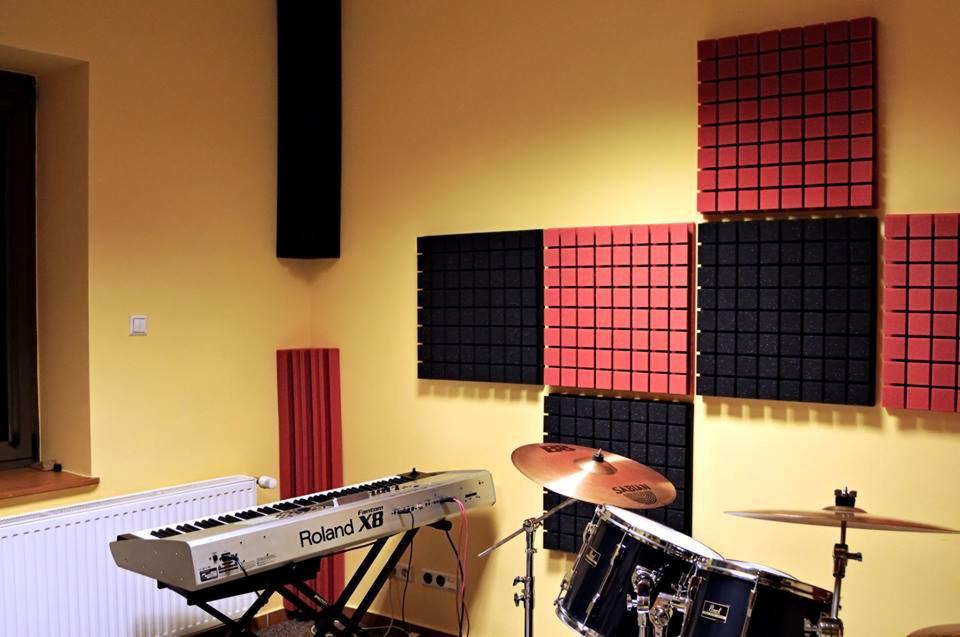 Pokój z panelami akustycznymi na ścianie, pianino Roland XB i perkusja z talerzem Sabian