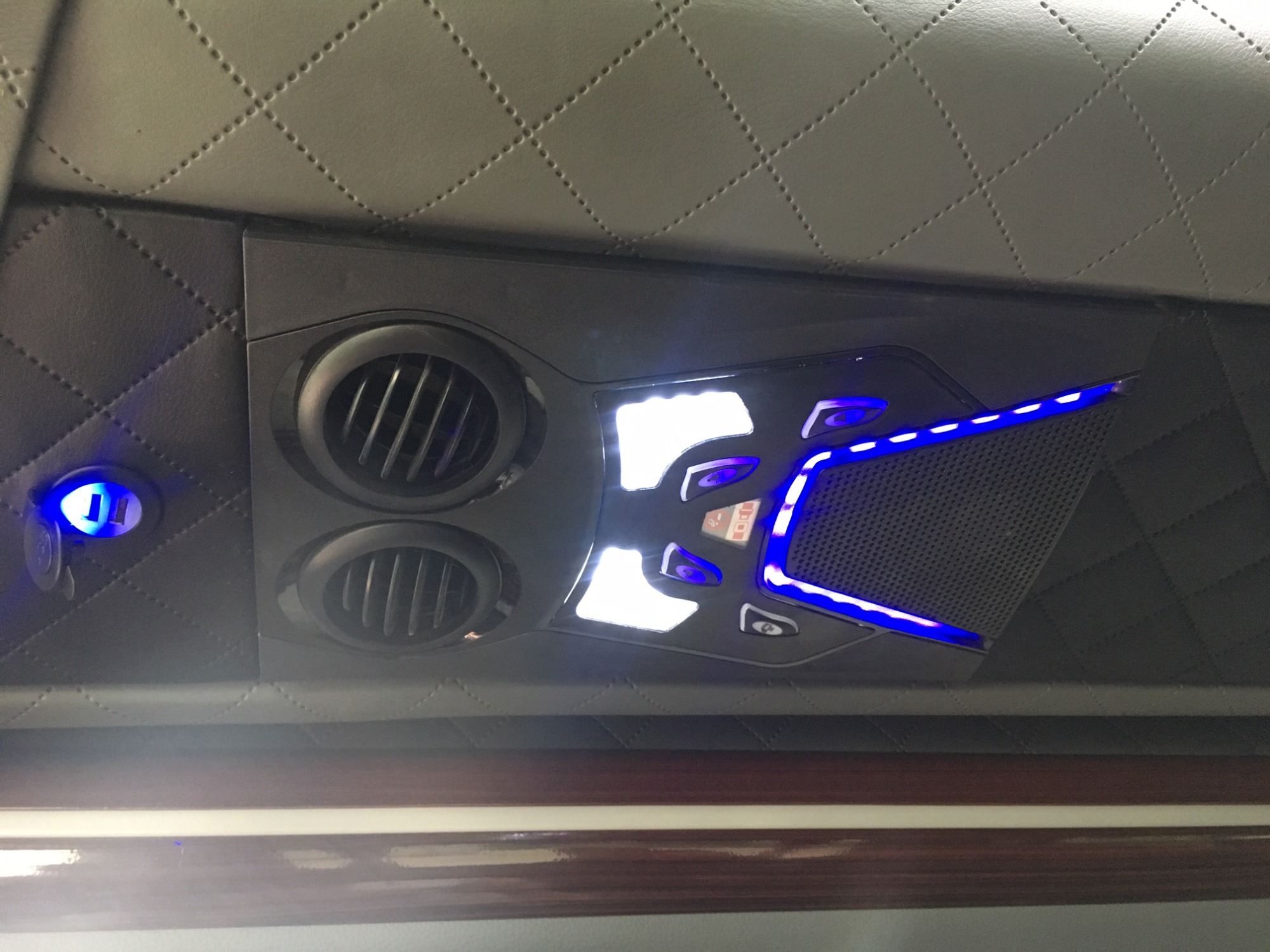 Wnętrze pojazdu z klimatyzacją i oświetleniem LED, widok na podsufitkę z ozdobnym przeszyciem w romby