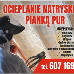 Pracownik w kombinezonie ochronnym i masce natryskuje pianę izolacyjną na poddasze, widoczne świeżo nałożone warstwy piany i dysza aplikatora.