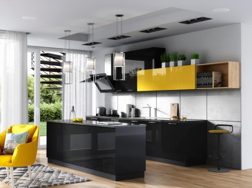 Nowoczesna kuchnia z czarnymi, błyszczącymi frontami, żółtymi akcentami i wyspą kuchenną, widoczny fragment salonu z żółtym fotelem i wzorzystym dywanem.