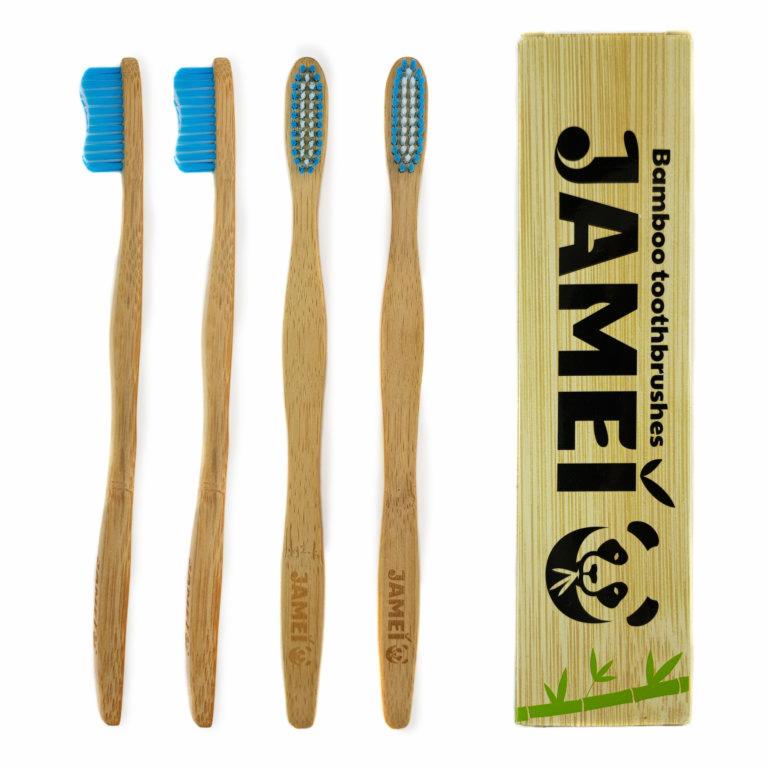 Cztery bambusowe szczoteczki do zębów z niebieskim włosiem, dwie z profilowanym włosiem, obok opakowanie z logo JAMEl i rysunkiem pandy na bambusowym tle.