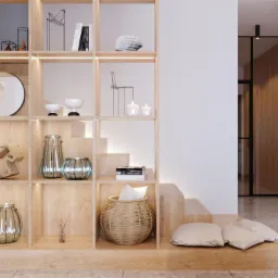 Drewniany regał z podświetleniem, wypełniony dekoracyjnymi przedmiotami: figurkami, wazonami i książkami, zintegrowany ze schodami i poduszkami na podłodze, w tle widoczna drewniana ściana i czarne...