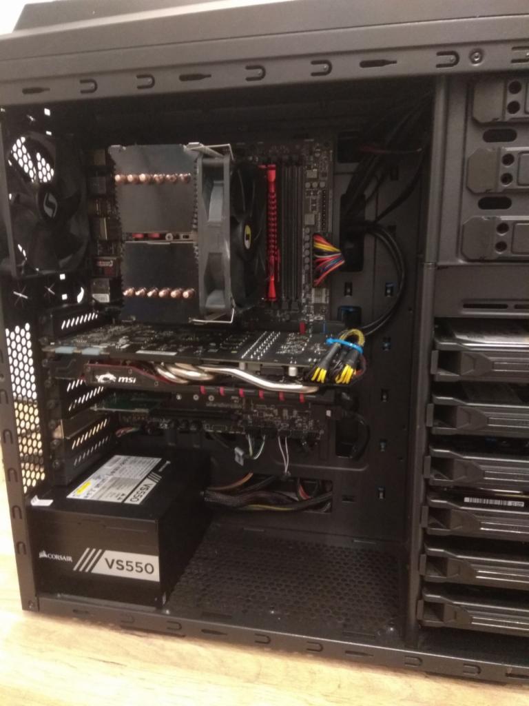 Wnętrze obudowy komputera stacjonarnego z widoczną płytą główną, kartą graficzną MSI, chłodzeniem procesora i zasilaczem Corsair VS550.