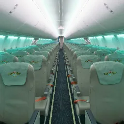 Wnętrze samolotu pasażerskiego z rzędami foteli obitych jasną skórą, z wyhaftowanym logo na zagłówkach, oświetlone turkusowym światłem.