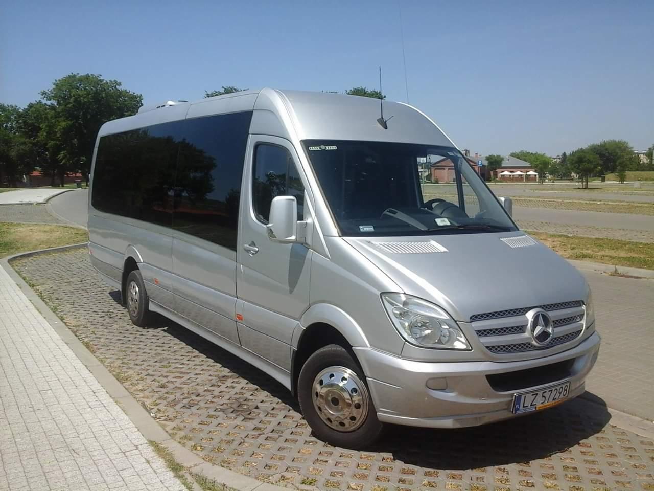 Srebrny bus Mercedes-Benz Sprinter z przyciemnianymi szybami, zaparkowany w Sitaniec-Wolica na ażurowej kostce brukowej w słoneczny dzień.
