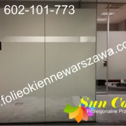Szklane ściany działowe w biurze, z folią okienną z poziomym paskiem, widoczny numer telefonu i adres strony internetowej firmy Sun Control.