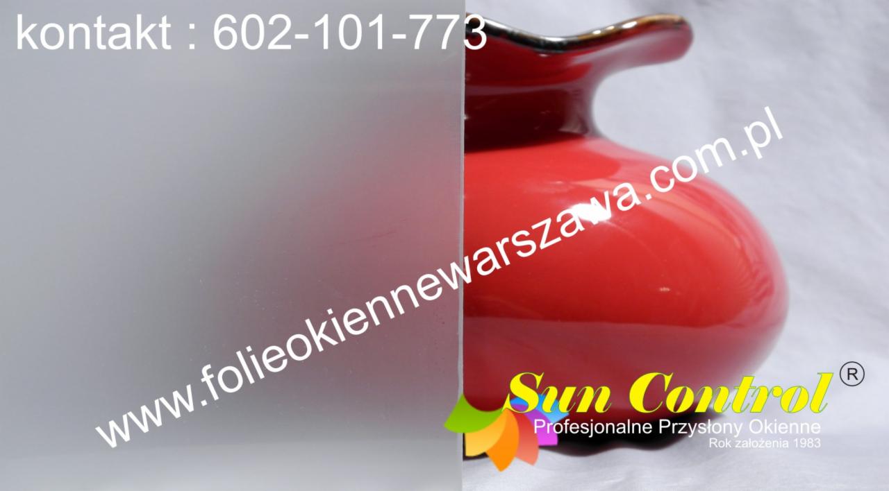 Okno z folią matującą, obok czerwony wazon i logo firmy Sun Control.