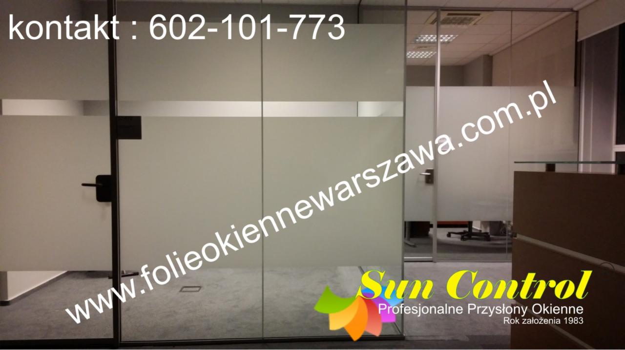 Szklane ściany działowe w biurze, z folią okienną z poziomym paskiem, widoczny numer telefonu i adres strony internetowej firmy Sun Control.