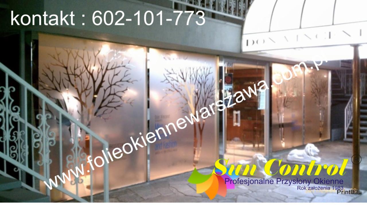 Szklane drzwi wejściowe do lokalu oklejone folią z motywem drzewa bez liści, widoczne logo firmy Sun Control i numer telefonu kontaktowego.