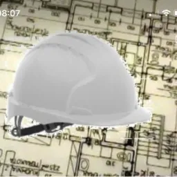 Biały kask ochronny na tle rozmazanego planu architektonicznego z widocznymi detalami pomieszczeń.