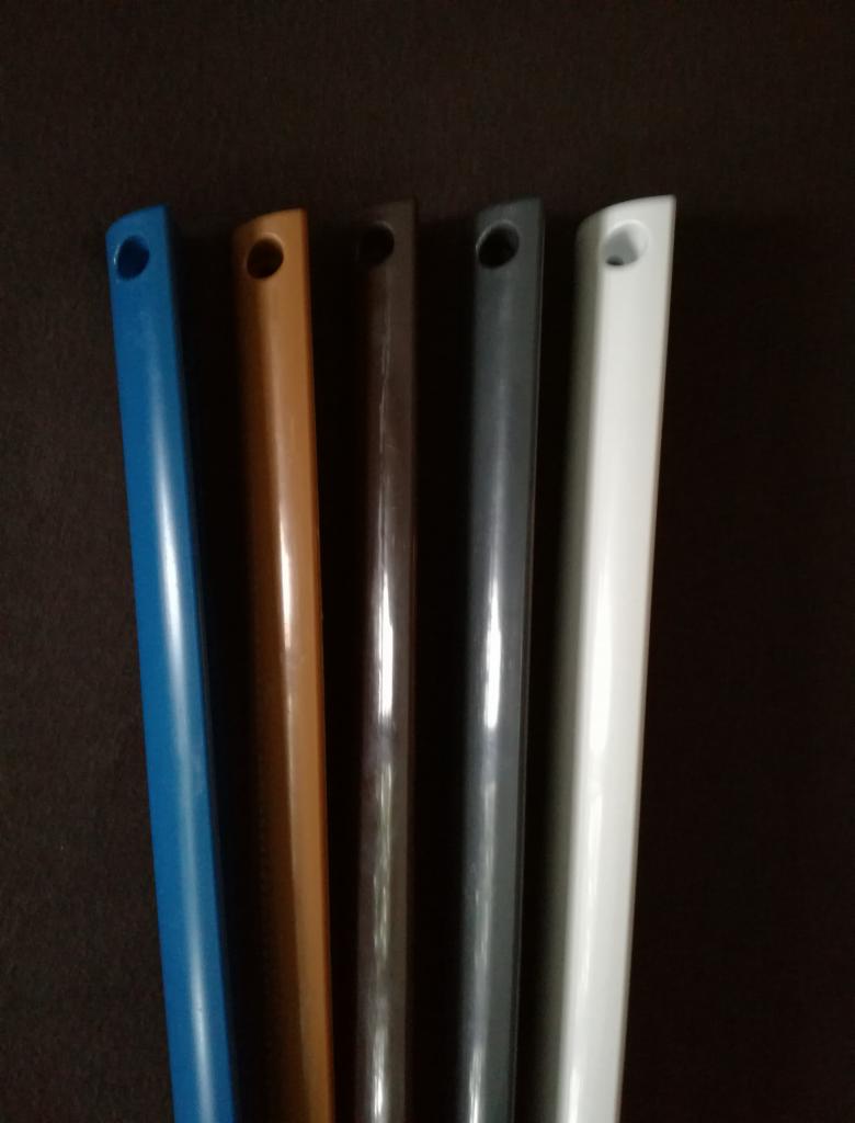 Pięć profili PCV w różnych kolorach (niebieski, brązowy, ciemnobrązowy, szary, biały) z otworem montażowym, ustawione pionowo na ciemnym tle.