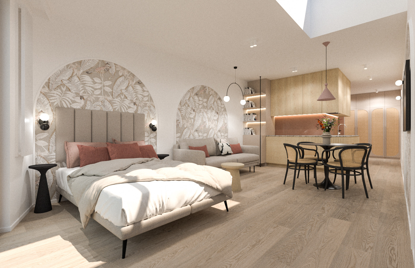 Wnętrze otwartej przestrzeni: sypialnia z łóżkiem, sofą i aneksem kuchennym, całość utrzymana w jasnej kolorystyce z motywem roślinnym na ścianie, oświetlona światłem dziennym wpadającym przez okno...