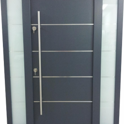 BUDMAR Producent okien i drzwi z drewna - Grafitowe drzwi wejściowe z długim, pionowym uchwytem i bocznymi szybami z mlecznego szkła, widoczne dwa klucze w zamku.